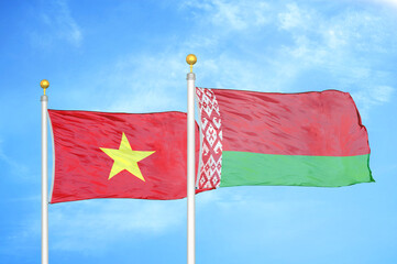 Vietnam and Belarus  two flags on flagpoles and blue sky