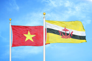 Vietnam and Brunei two flags on flagpoles and blue sky