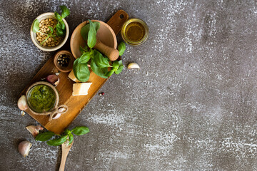 ingredients to cook homemade italian sauce pesto basil, garlic, parmigiano, olive oil and pine nuts horizontale