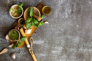 ingredients to cook homemade italian sauce pesto basil, garlic, parmigiano, olive oil and pine nuts horizontale
