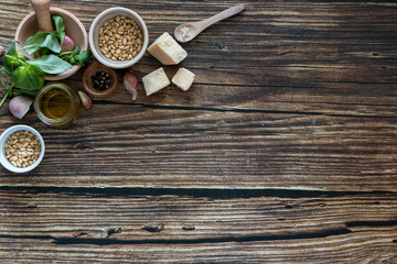 ingredients to cook homemade italian sauce pesto basil, garlic, parmigiano, olive oil and pine nuts horizontale