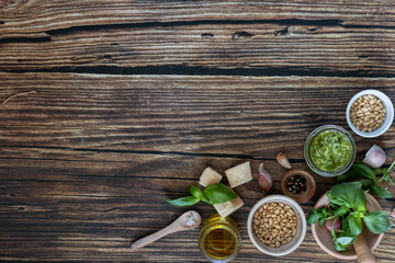 ingredients to cook homemade italian sauce pesto basil, garlic, parmigiano, olive oil and pine nuts horizontale