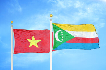 Vietnam and Comoros two flags on flagpoles and blue sky