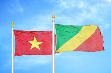 Vietnam and Congo  two flags on flagpoles and blue sky