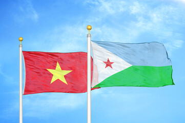 Vietnam and Djibouti two flags on flagpoles and blue sky