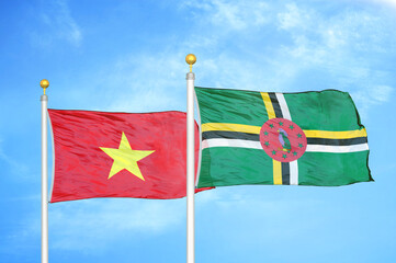 Vietnam and Dominica two flags on flagpoles and blue sky