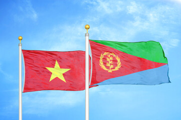 Vietnam and Eritrea two flags on flagpoles and blue sky