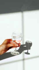 The hands of a woman who is holding a glass of water