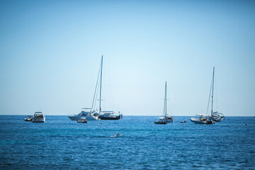 Fototapeta premium The boat is moored in the blue sea harbor. Tilt-shift effect. Caldera of an underwater volcano. Romantic Santorini island in Greece.