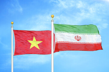 Vietnam and Iran two flags on flagpoles and blue sky
