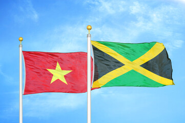 Vietnam and Jamaica two flags on flagpoles and blue sky