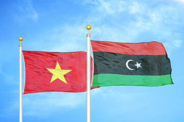 Vietnam and Libya two flags on flagpoles and blue sky