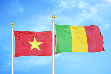 Vietnam and Mali two flags on flagpoles and blue sky