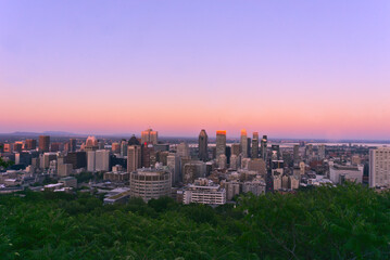 An aerial skyline view of a city skyscrapers, buildings, and streets taken from a mountain at sunset, Montreal, QC, Canada