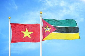 Vietnam and Mozambique two flags on flagpoles and blue sky