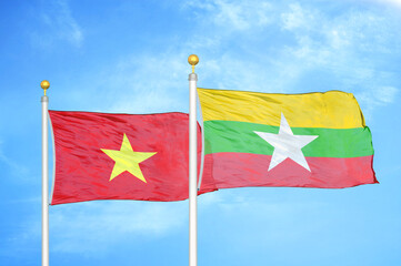 Vietnam and Myanmar two flags on flagpoles and blue sky