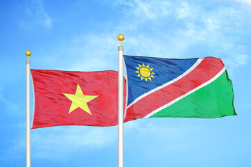 Vietnam and Namibia two flags on flagpoles and blue sky