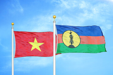 Vietnam and New Caledonia two flags on flagpoles and blue sky