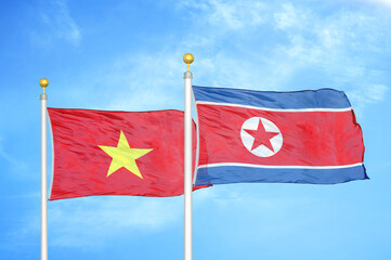 Vietnam and North Korea two flags on flagpoles and blue sky