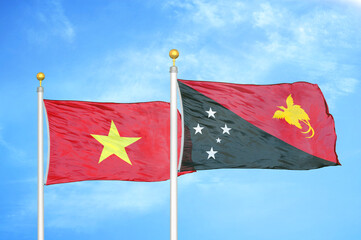 Vietnam and Papua New Guinea two flags on flagpoles and blue sky