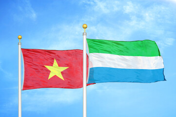 Vietnam and Sierra Leone two flags on flagpoles and blue sky