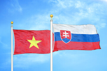 Vietnam and Slovakia two flags on flagpoles and blue sky