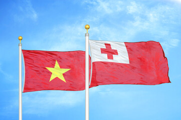Vietnam and Tonga two flags on flagpoles and blue sky
