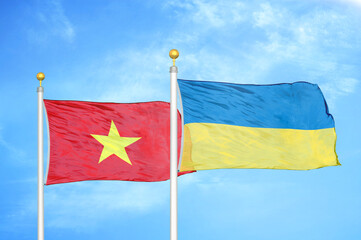 Vietnam and Ukraine two flags on flagpoles and blue sky