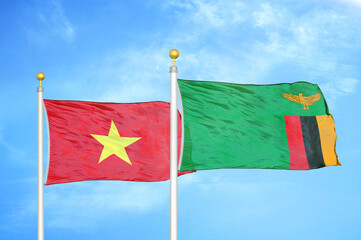 Vietnam and Zambia two flags on flagpoles and blue sky