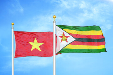 Vietnam and Zimbabwe two flags on flagpoles and blue sky