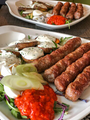 grilled meatballs and potatoes with salad on plate