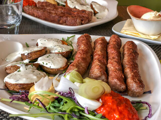 grilled meatballs and potatoes with salad on plate