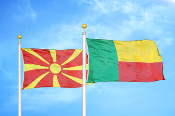 North Macedonia and Benin two flags on flagpoles and blue sky