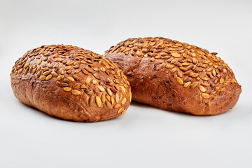 Organic wholmeal bread on white background. Two loaves of artisan bread with pumkin seeds. Healthy bread recipe.