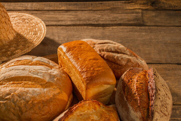 Various types of organic bread on wooden background. Artisan bread background. Copy space.
