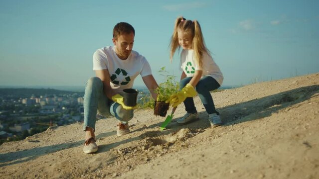 Father and daughter plant tree care green group garden man environment agriculture planet ecology teamwork gardening slow motion