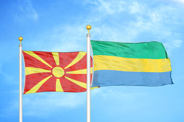 North Macedonia and Gabon two flags on flagpoles and blue sky