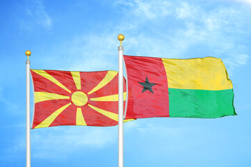 North Macedonia and Guinea-Bissau two flags on flagpoles and blue sky