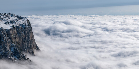 The snow plateau rises above the dense fog, horizontally panoramic