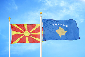 North Macedonia and Kosovo two flags on flagpoles and blue sky