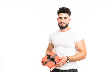 Handsome bearded overjoyed man wearing casual clothes holding present box standing isolated over white background