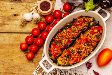 Karniyarik traditional Turkish food from stuffed eggplants with minced meat, tomato, greens and sesame seeds