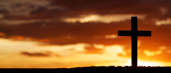 Silhouette cross against the sky At Sunset. Dramatic nature background. Crucifixion Of Jesus Christ. Religion concept.