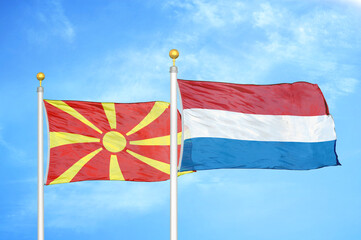 North Macedonia and Netherlands two flags on flagpoles and blue sky