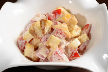 Salad served in the restaurant tomatoes fried bread and cheese seasoned with mayonnaise, close up. Photos for restaurant and cafe menus