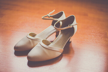 wedding shoes of the bride on a wooden floor in sepia