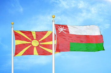 North Macedonia and Oman two flags on flagpoles and blue sky