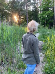 Frau von hinten schaut in den Sonnenuntergang