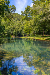 Beautiful clear river flowing through the woods with hiking trail in park