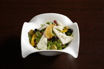Delicious and healthy salad with vegetables and cheese seasoned with olive oil. Photos for restaurant and cafe menus
